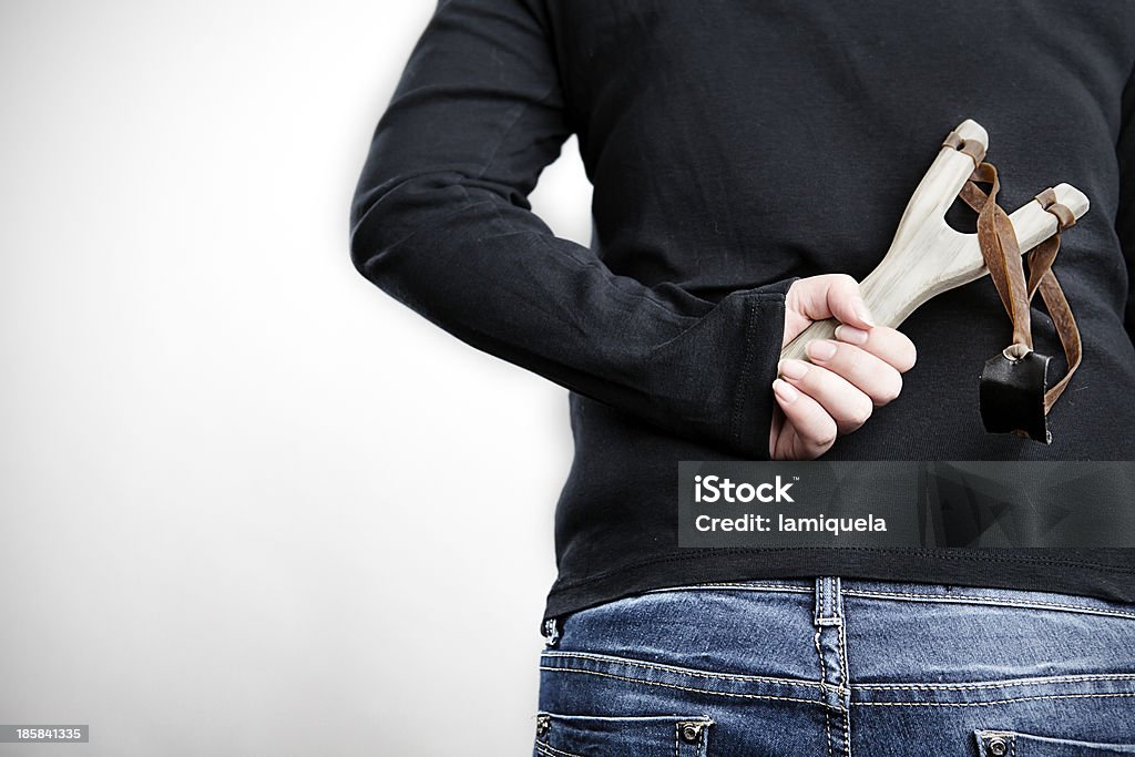 The bully Back view of a teenager holding a wood slingshot Boys Stock Photo