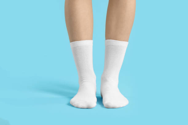istock Woman in stylish white socks on light blue background, closeup 1858414201