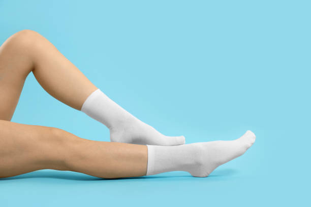 istock Woman in stylish white socks on light blue background, closeup. Space for text 1858415920