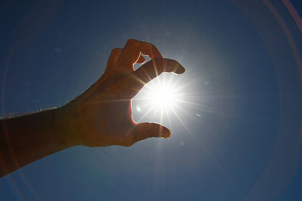 istock One Hand Catching the Sun Stars on a Blue Background 185841677