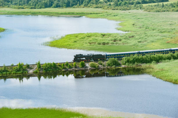 istock Retro steam train moves along the lake. 1858424644
