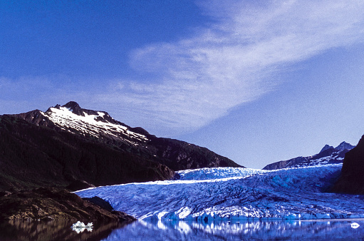 Wide view of Southeast Alaska's Mendenhall Glacier, as it slowly moves down into Mendenhall Lake.

Taken in Mendenhall Valley near Juneau, Alaska, USA