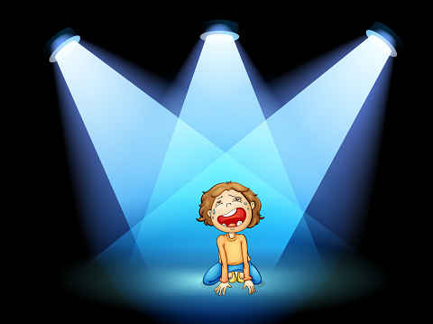 girl crying in the middle of the stage with spotlights