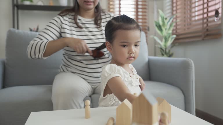 Mother doing her daughter's hair with comb