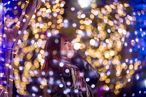 Happy young woman looking at Christmas lights