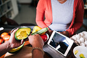 Couple preparing a meal together from an online recipe on a tablet
