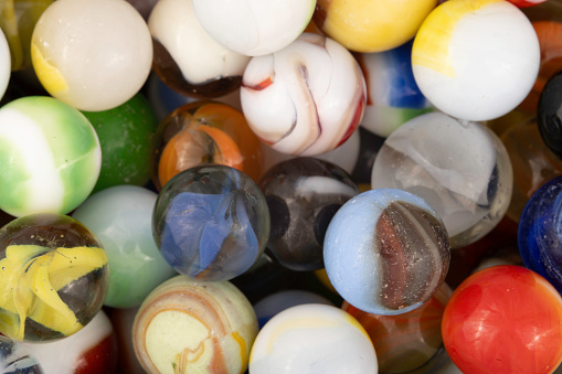 A bunch of old marbles with dents nicks and pits from age and use