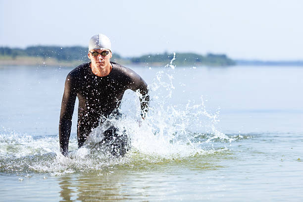 atleta corre fuori dall'acqua - competitive sport competition swimming wetsuit foto e immagini stock