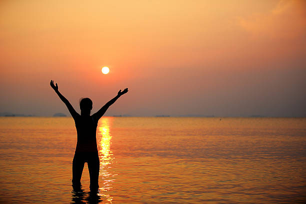 istock cheering  woman seaside sunrise 185847895