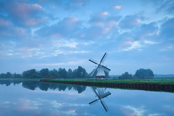 istock Dutch windmill close to river during calm sunrise 185852840