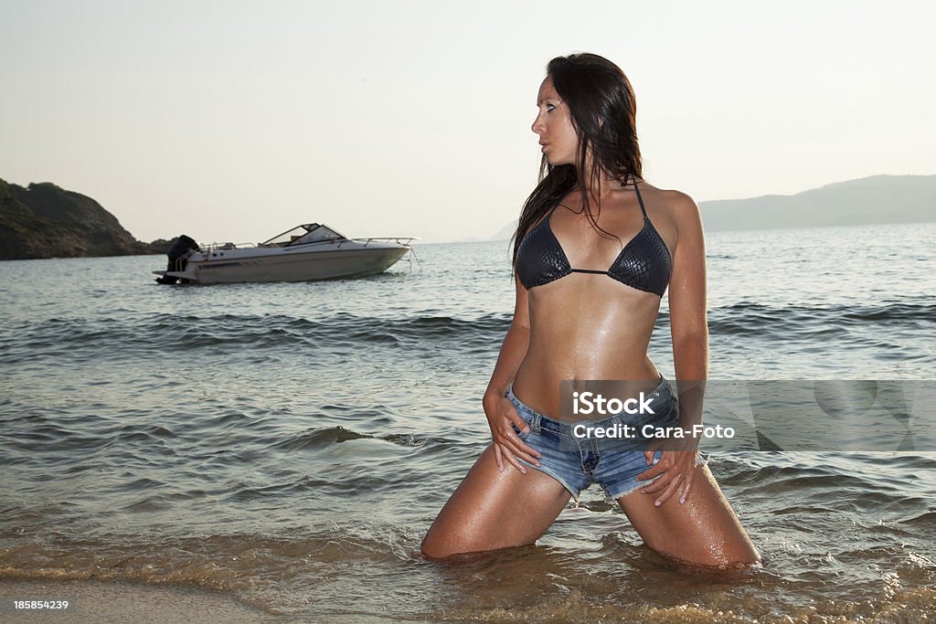 Pretty woman with hot pands and boat on the beach Adult Stock Photo