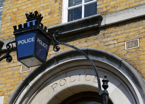 A Police sign above the doorway to a police station in London, United Kingdom