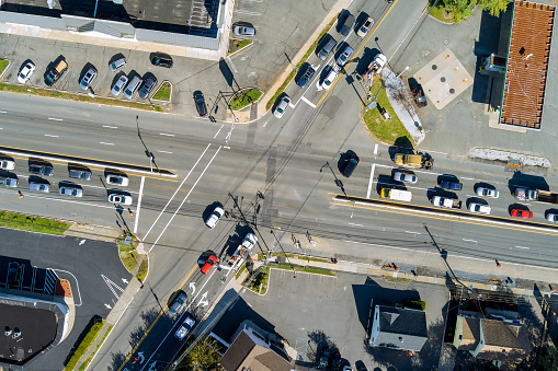 An aerial view of road intersection during rush hour with heavy traffic moving on road