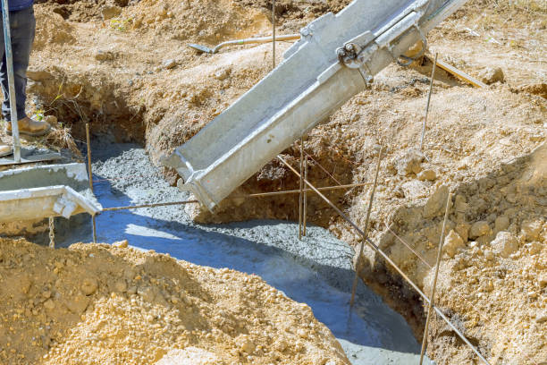 istock Worker pouring concrete foundation for new house 1858545539