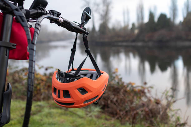 istock Orange bicycle helmet hangs from handle bar of bike 1858603516