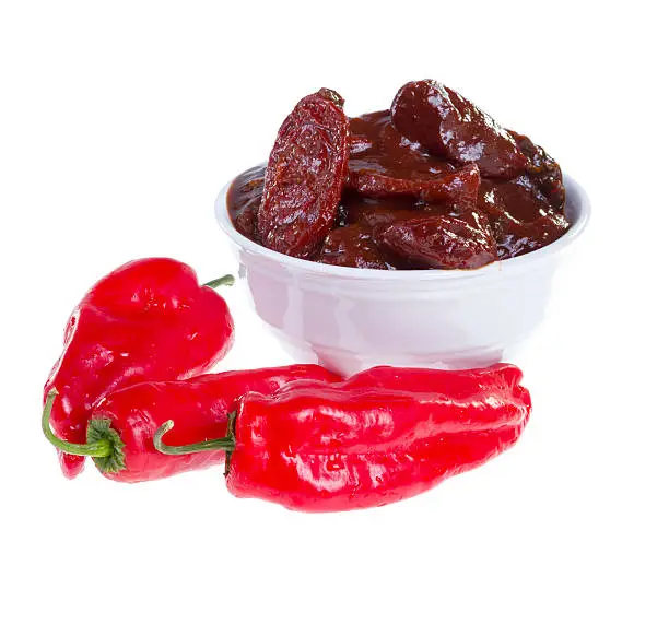 Red jalapeno peppers and chipotles (smoke-dried pods) in adobo sauce isolated on white background.