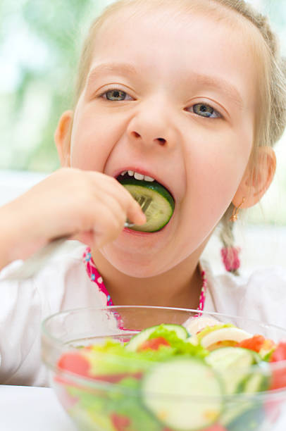 istock child eating vegetable salad 185870587
