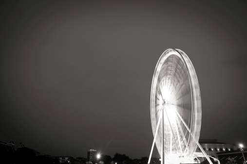 Fairy wheel in an amusement park during night time, taken at slow shutter.