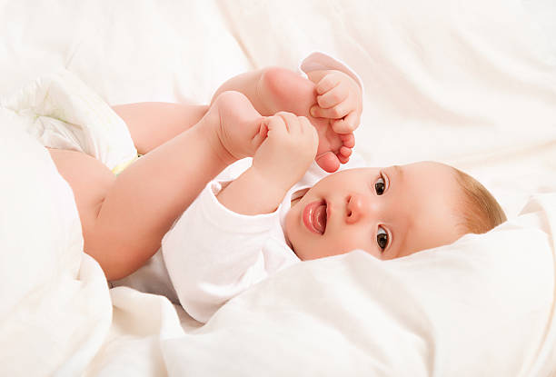 istock Happy baby plays with his legs 185871408