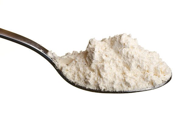 white weizen mehl pulver auf einem löffel - table spoon stock-fotos und bilder