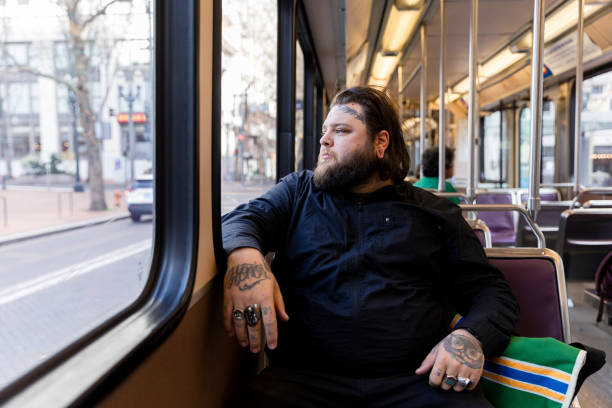 istock Tattooed Man Rides Public Transit Train Through City for Work 1858781133