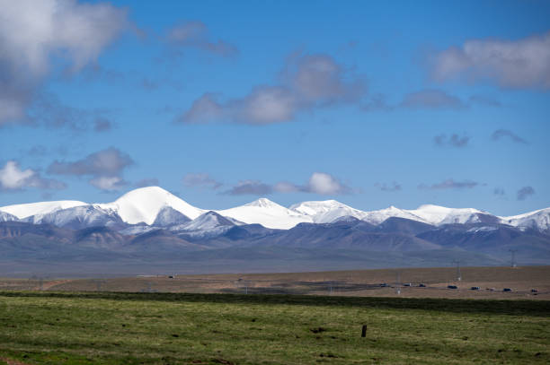 istock Plateau snow capped mountains and meadows under blue sky and white clouds 1858790548