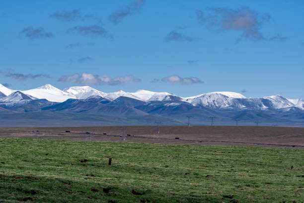 istock Plateau snow capped mountains and meadows under blue sky and white clouds 1858792105
