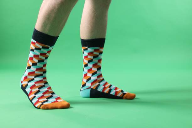 istock Man in stylish colorful socks on light green background, closeup. Space for text 1858804021