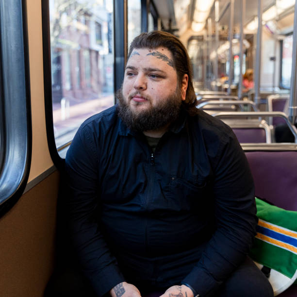 istock Tattooed Man Rides Public Transit Train Through City for Work 1858811768