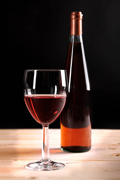 istock Rose wine glass and bottle on wooden table 185883829