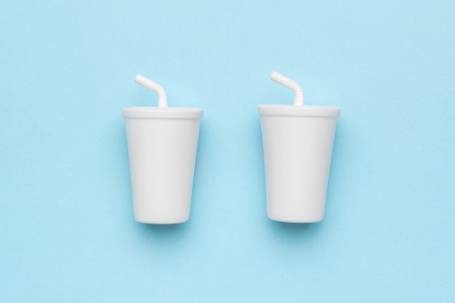Two large white drinks glasses on a blue background. A container for drinks.