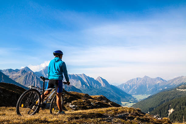 Mountain biker stopped on rocky hillside Mountain biking - woman on bike, Dolomites, Italy mountain biking photos stock pictures, royalty-free photos & images
