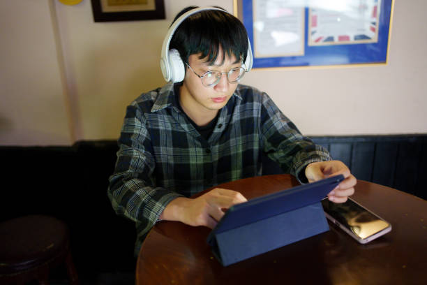 istock Man looking at tablet with headphones 1858902727