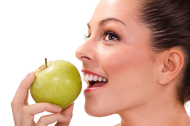 istock healthy woman eating green apple 185891148