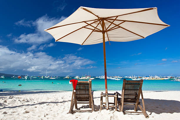 istock Sun umbrella with Santa Claus Hat on chairs 185895578