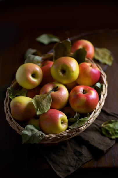 istock Ripe apples in a basket, with leaves around it 1858960211