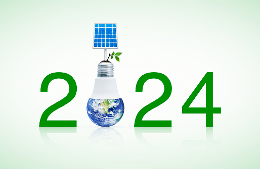 2024 text with solar cell and fresh green tree leaves on soil with earth globe inside led light bulb, Happy new year 2024 green ecology and saving energy concept, Elements of this image furnished by NASA