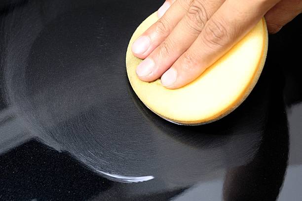 Hand applying car polish with an orange pad stock photo