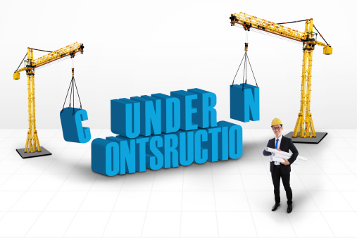 Under construction concept with two yellow cranes at the sides