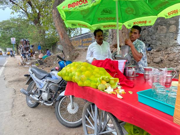 Coimbatore, Tamil Nadu, India - October 10 2023: A hawker selling fresh sweet lime juice on a sidewalk in the city.