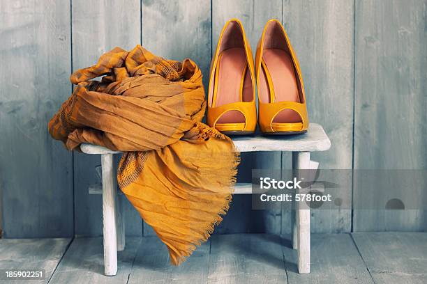 A White Stool With Dark Yellow Shoes And A Scarf On It Stock Photo - Download Image Now