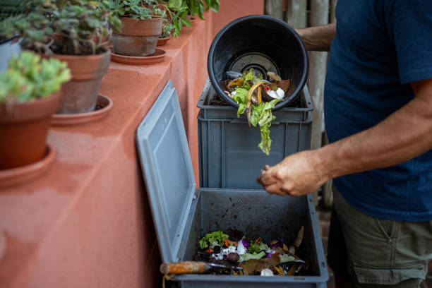 Man composting organic remains in home composter Man composting organic remains in home composter - Buenos Aires - Argentina eisenia fetida stock pictures, royalty-free photos & images