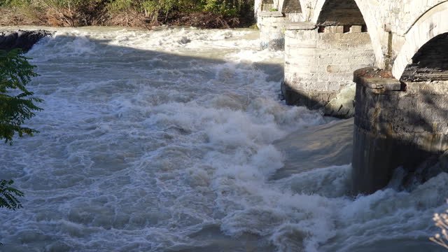 The Serio river swollen after heavy rainfall and floodwater crashing through valley. The water flows fast from the high valley to the plain. River in Province of Bergamo, northern Italy