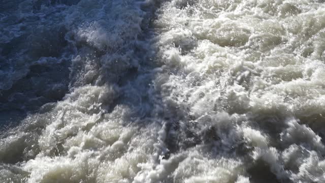 Up and down drone aerial view of the a river swollen after heavy rains. The water flows quickly. Risk of flooding and overflow. General contest of a river flood