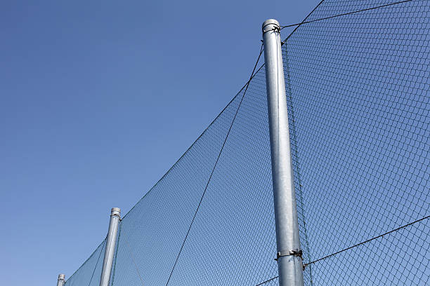 istock metal wire fence with blue sky in background 185909022