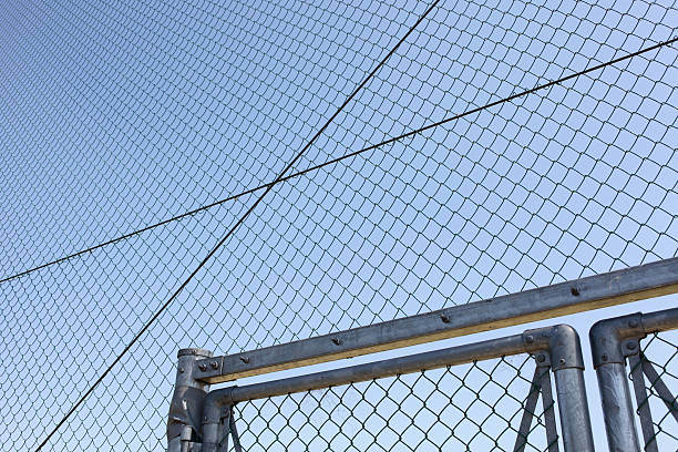 istock metal wire fence with blue sky in background 185909040