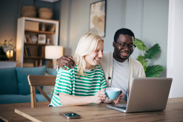 istock Happy young couple using laptop and relaxing with coffee 1859099451