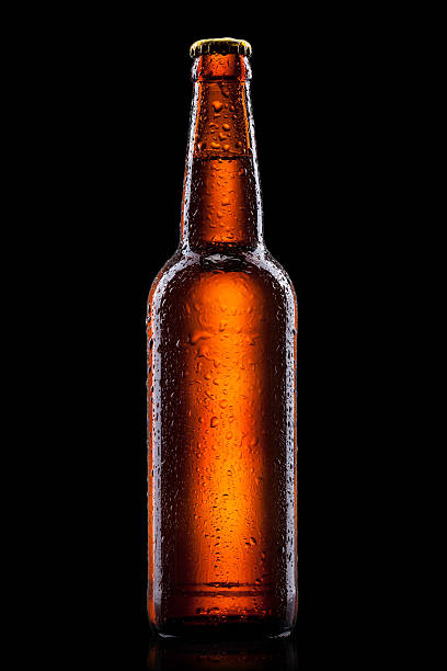 istock Beer bottle with water drops isolated on black 185911213