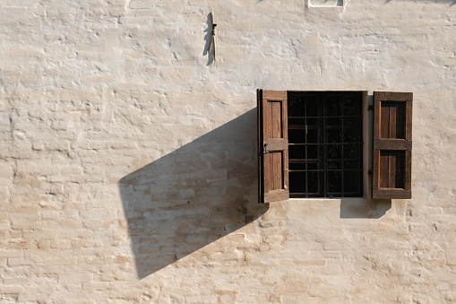 Wooden window on the facade of the country house. Plastered brick wall of the facade of an Italian farmhouse.  Stock photos. Busseto, Parma, Italy.