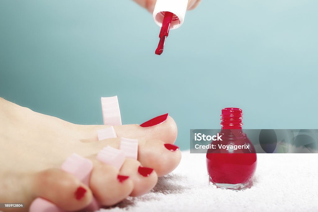 Pédicure appliquant des ongles rouge sur bleu - Photo de Adulte libre de droits